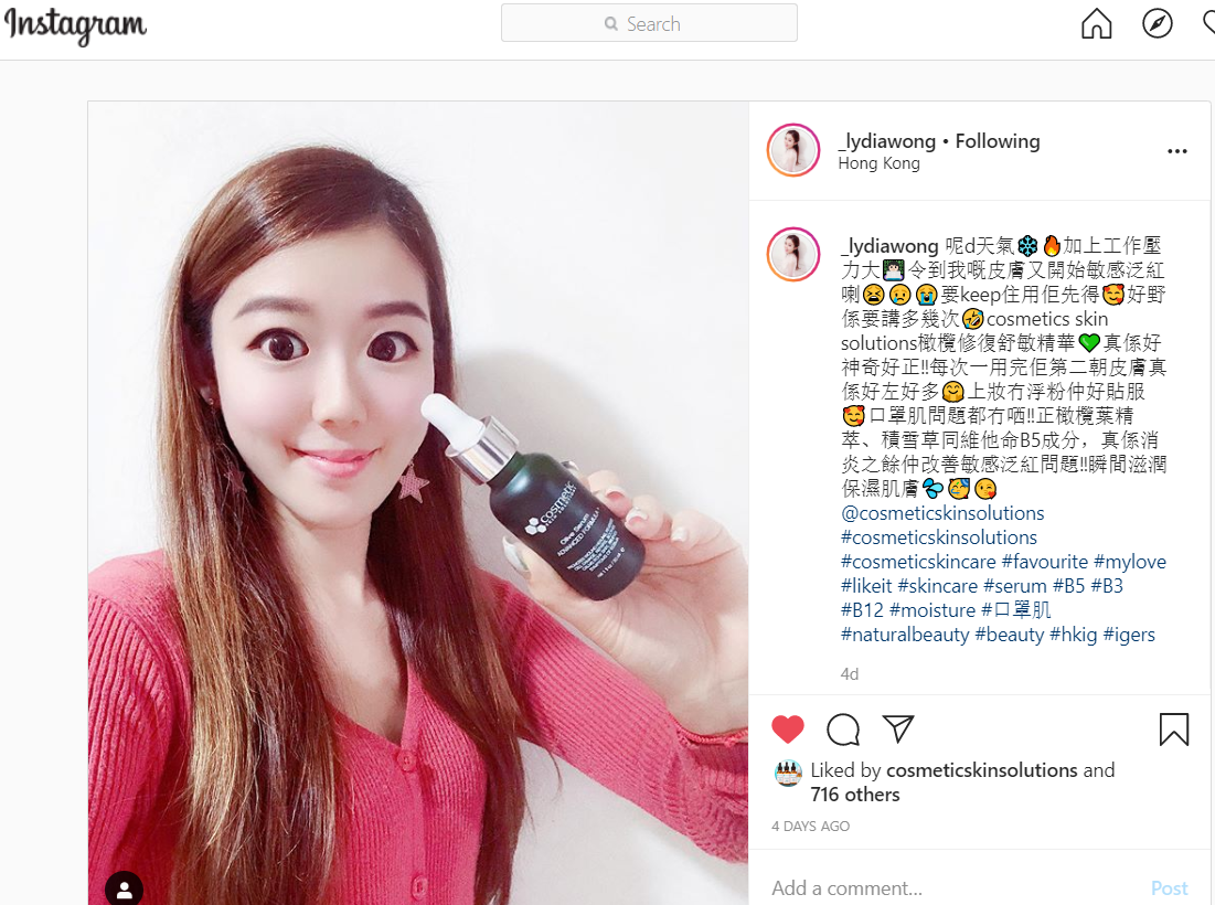 Lydia Wong holding up a bottle of Supreme Olive Serum with a smile on her face